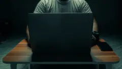 Homem sentado em computador