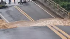 Ponte rompida em duas partes, com rio passando pelo meio