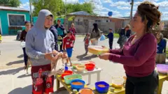 María José Games entregando comida no refeitório comunitário 'Pequeños Valientes', no bairro de El Claro, em Benavídez.