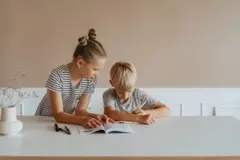 menina ajudando irmão mais novo em tarefa