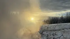 Fumaça sobre a neve durante por do sol em estrada