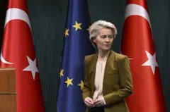 Avrupa Birliği (AB) Komisyonu Başkanı Ursula von der Leyen Türkiye ve AB bayrakları önünde duruyor.