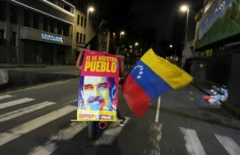 Motocicleta com apoiador de Maduro segura cartaz com imagem do líder venezuelano e bandeira da Venezuela