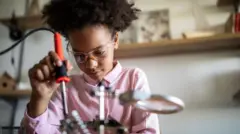 Menina operando uma máquina de solda