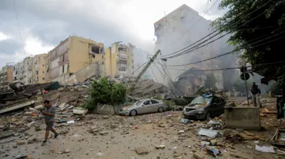 A man walks near buildings damaged in an Israeli strike in Beirut's southern suburbs, Lebanon (1 October 2024)