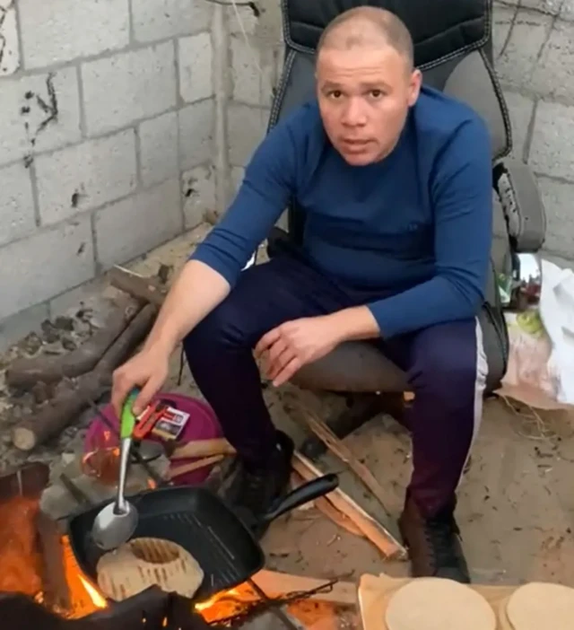 Jehad cozinha para a família em fogueira improvisada