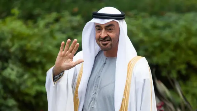 O príncipe herdeiro de Abu Dabi, Mohammed bin Zayed Al Nahyan, em roupas típicas árabes acena 