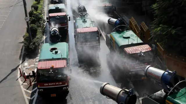 Caminhões borrifando água nas ruas e calçadas