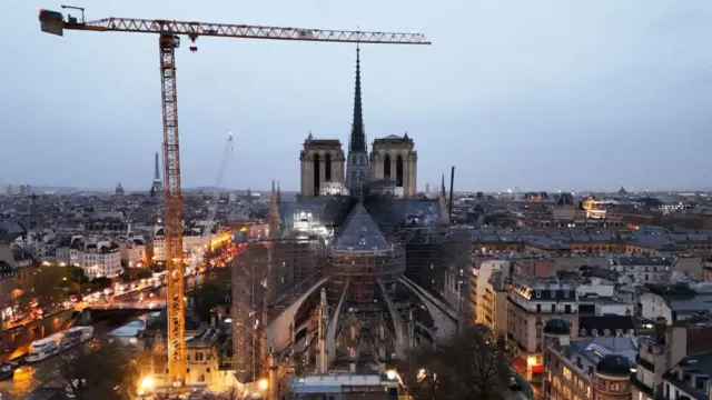 Esta fotografia aérea mostra um guindaste próximo a um andaime na catedral de Notre-Dame de Paris enquanto o sol nasce alguns dias antes de sua reabertura, em 25 de novembro de 2024.