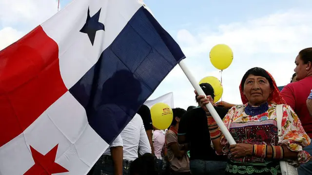 Mulher panamenha no Canal com uma bandeira de seu país 