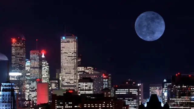 Lua cheia à noite com prédios à frente