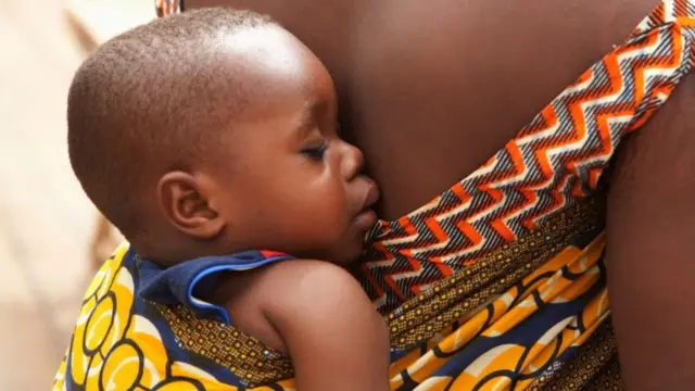 Bebê dormindo no colo da mãe