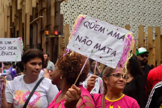 Placa escrito "quem ama não mata" em protesto contra violência contra a mulher