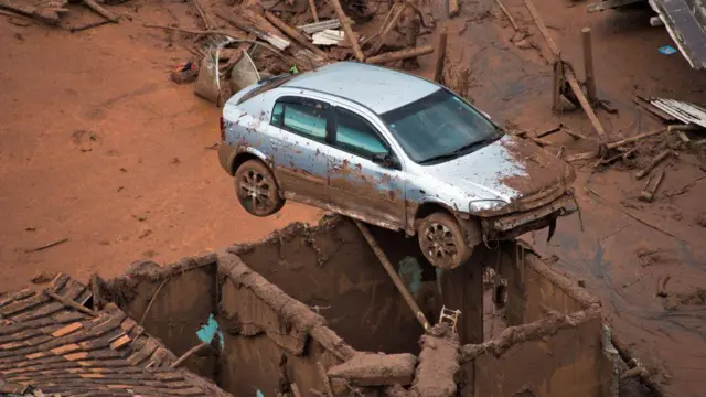 Carro em cima de casa na lama