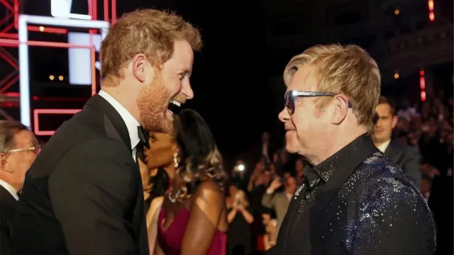 Príncipe Harry conversa com Elton John