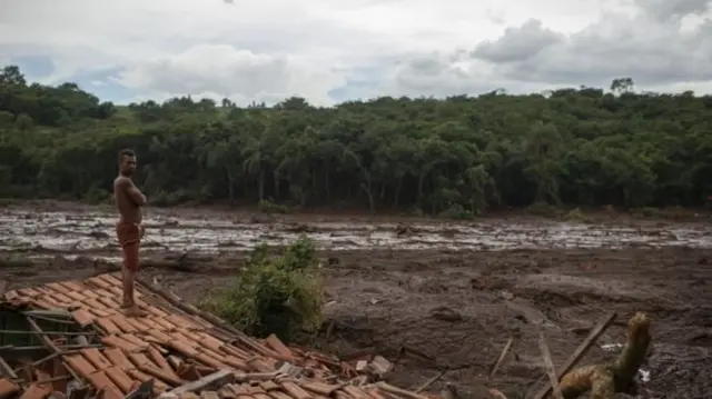 Homem em telhado sobre a lama de Brumadinho