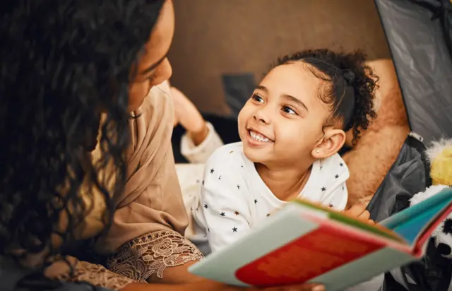 Mãe lendo livro para a filha