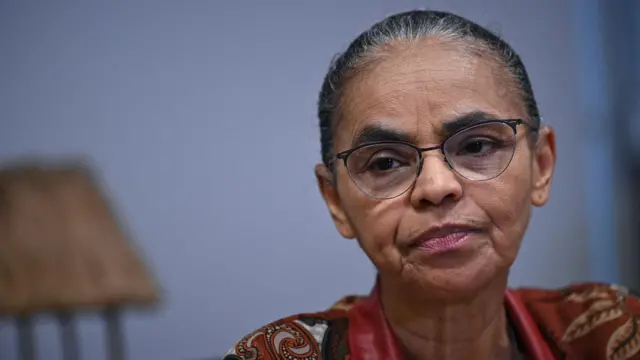 Marina Silva com olhar fechado durante entrevista em sala