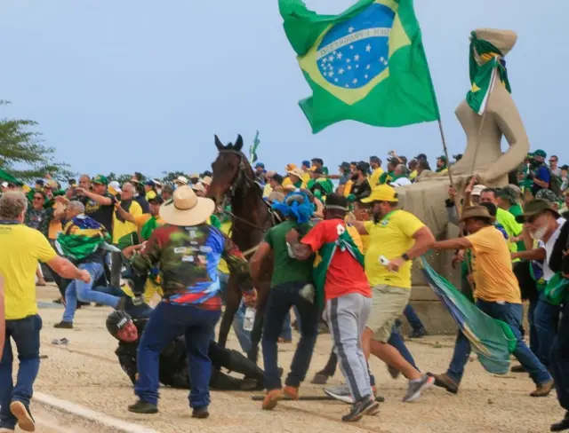 Policial militar é atacado por militantes bolsonaristas ao cair do cavalo na Praça dos Três Poderes, neste domingo