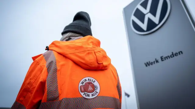 Uma mulher de jaqueta laranja adere à greve em uma das fábricas da Volkswagen.