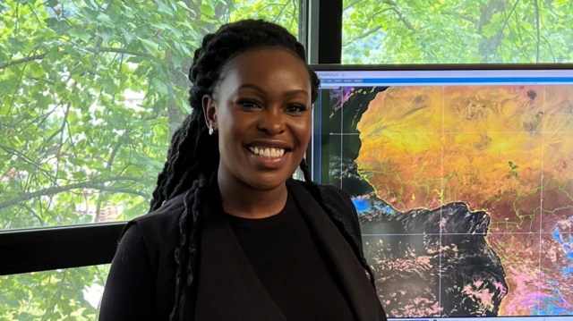 Sarah Kimani sorrindo em sala com janela para árvores; ao lado dela, uma imagem de satélite