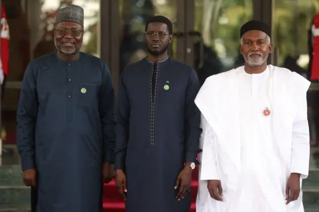 Le président de la Commission de la Communauté économique des États de l'Afrique de l'Ouest (CEDEAO) Omar Touray (G), le président du Sénégal Bassirou Diomaye Faye (C) et le ministre nigérian des Affaires étrangères Yussuf Tuggar (D) posent pour une photo lors de la 66e session ordinaire de l'Autorité des chefs d'État et de gouvernement de la CEDEAO à Abuja, le 15 décembre 2024.