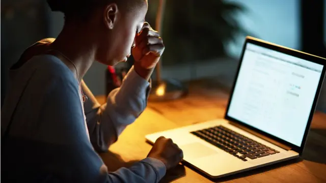 Mulher preocupada em frente a um computador