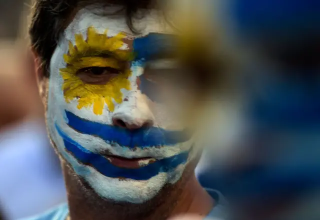 Homem com o rosto pintado com a bandeira do Uruguai 