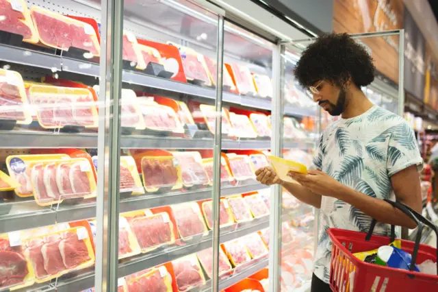 Homem comprando carne em supermercado