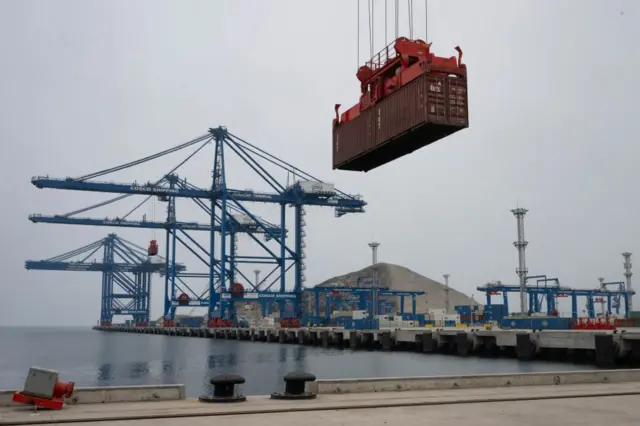 Um contêiner é transportado por um guindaste no porto de Chancay.