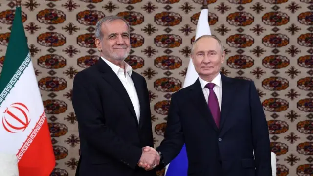 Vladimir Putin apertando a mão de Masoud Pezeshkian, em Ashgabat, no dia 11 de outubro de 2024