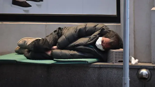 Homem sem-teto dorme na calçada da cidade de Daegu