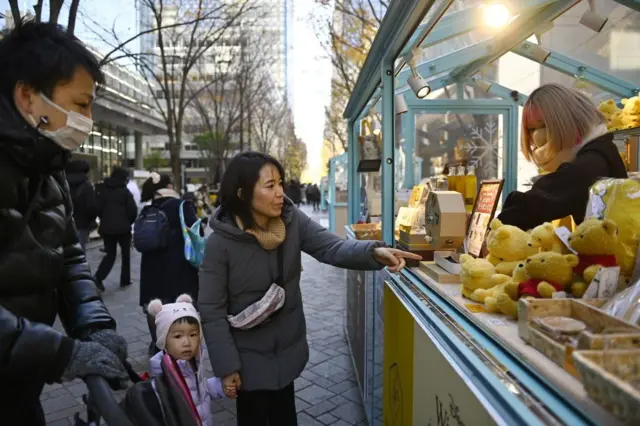 Pessoas em frente a uma banca de rua no Japão