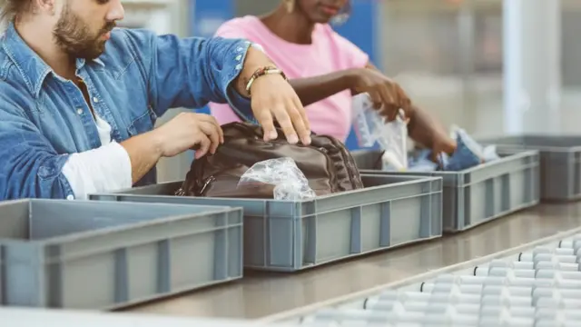 Turistas colocando itens na esteira para passar pela checagem de segurança do aeroporto