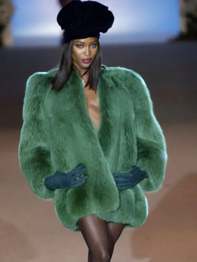 A modelo Naomi Campbell vestindo turbante e casaco de Yves Saint-Laurent no desfile de retrospectiva da obra do estilista no centro cultural parisiense George Pompidou em 2002