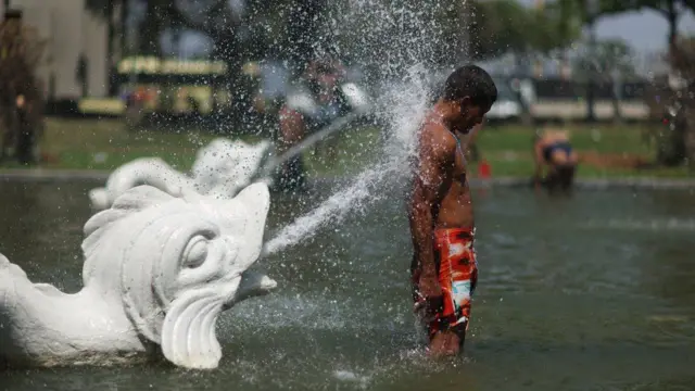 Homem se refresca em chafariz no Rio de Janeiro