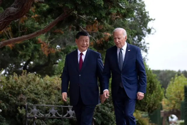 Xi e Biden caminhando e conversando em jardim