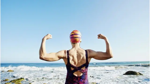 Mulher diante do mar pronta para nadar