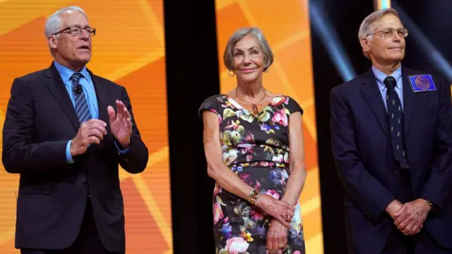 Rob, Alice e Jim Walton juntos no palco. a mulher esta no meio