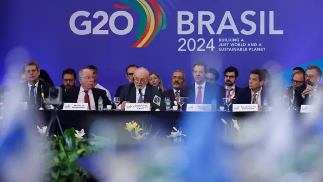 Lula discursa em evento do G20, sentado ao lado de ministros do seu governo