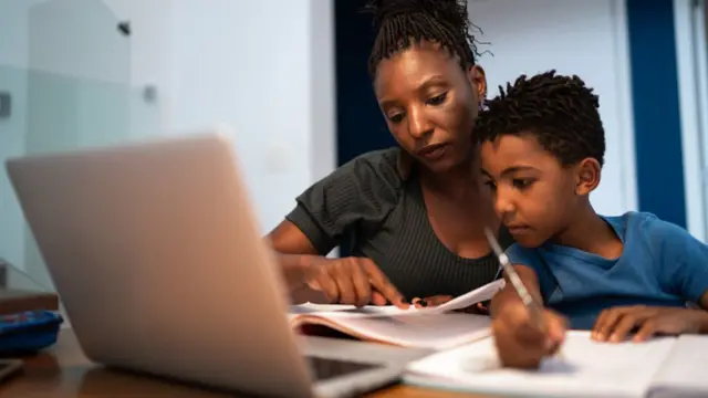 Mãe e filho estudando em notebook