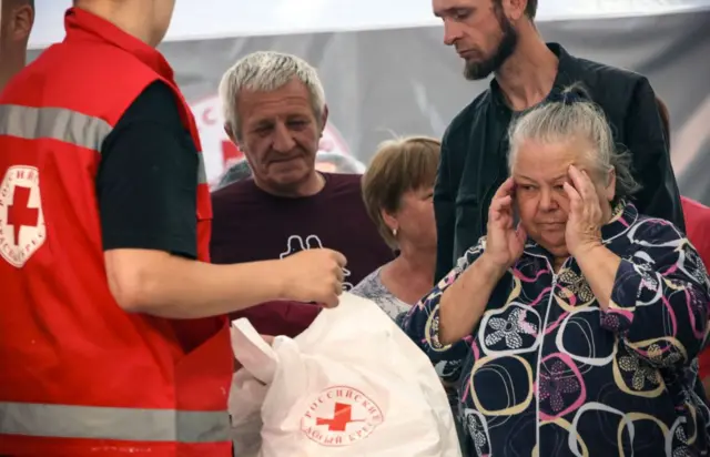 Pessoas desalojadas pela guerra recebendo ajuda humanitária em um centro de distribuição da Cruz Vermelha em Kursk.