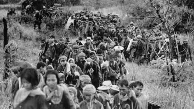 Groupe de réfugiés marchant dans le maquis, photo en noir et blanc