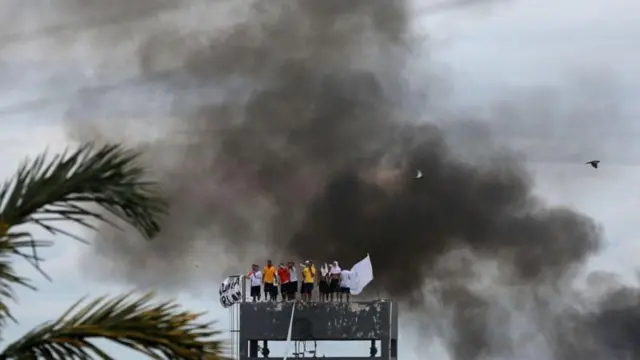 Homens em cima de torre de presídio durante rebelião