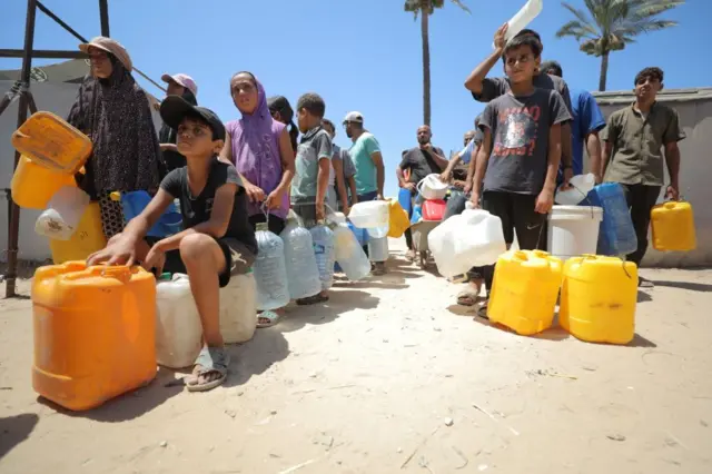 Pessoas em fila com garrafas de água