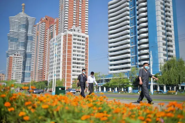 Pedestres caminham pela rua dos Cientistas de Mirae, em Pyongyang