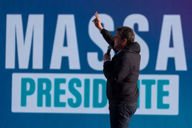 Massa com uma placa atrás dele que diz "Massa Presidente "