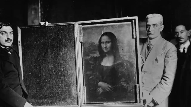 Dois homens carregam a pintura da Mona Lisa de volta ao Louvre por volta de 1914 em Paris, França