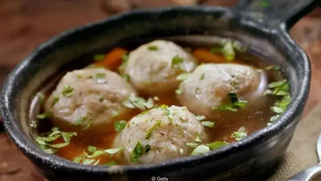 Foto de uma pequena panela de ferro com bolas de carne em um caldo