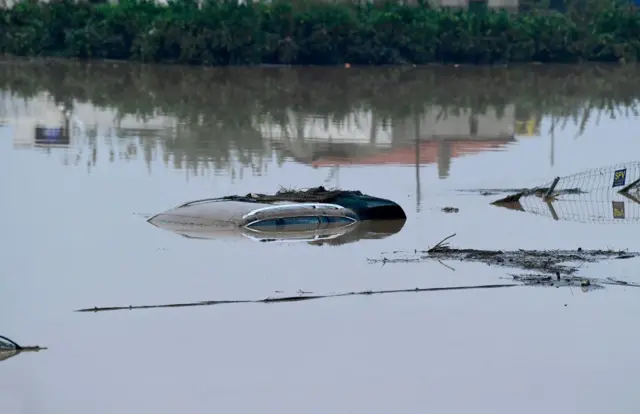 Carro submerso na Espanha; somente teto é visível para fora da água